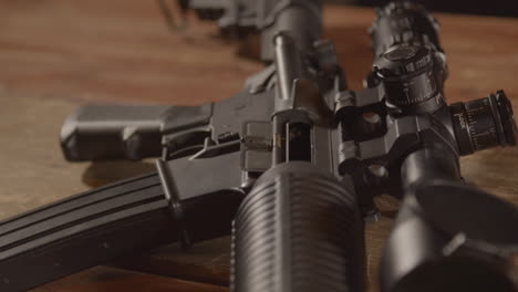 Close-dolly-over-a-loaded-AR-15,-ending-on-a-close-up-of-a-barrel-aiming-towards-camera