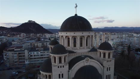 Aerial,-medium-rotating-shot-about-the-orthodox-cathedral-in-the-centrum-of-Deva,-Romania-on-a-early-spring-evening
