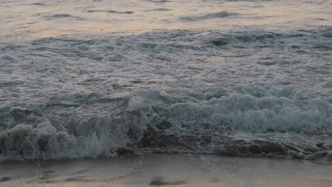 Riesige-Wellen-Aus-Dem-Wilden-Pazifik-Rollen-Auf-Den-Sandstrand,-Während-Mehrere-Menschen-Kurz-Nach-Sonnenuntergang-In-Mexiko-Im-Meer-Schwimmen