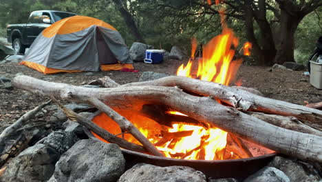 Campfire-with-camping-tent-in-the-background,-trekking-in-the-wilderness-nature,-outdoor-activities