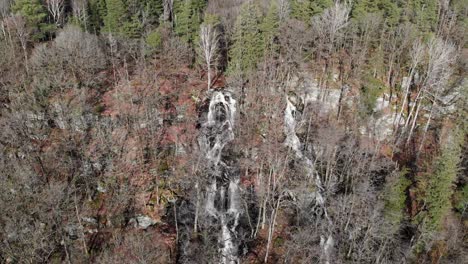 Malerische-Landschaft-Des-Wasserfalls,-Der-Durch-Waldbäume-In-Den-See-Fließt