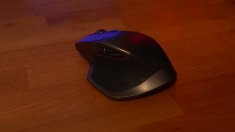 Mouse-on-wooden-desk-with-red-and-blue-reflections