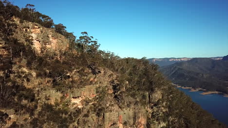 Antena:-Rastreo-De-Drones-Alrededor-De-Una-Montaña-Para-Revelar-Un-Hermoso-Lago-Azul-En-Nueva-Gales-Del-Sur,-Australia
