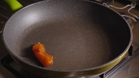 Chef-is-Frying-Pieces-of-Chicken-on-a-Hot-Pan,-Using-a-Kitchen-Tong