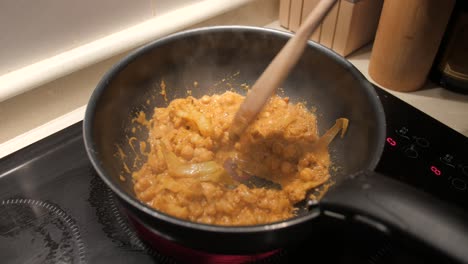 Cocinar-Y-Revolver-Curry-Indio-Vegano-Con-Una-Cuchara-De-Madera-En-Una-Sartén