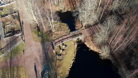 Top-down-aerial-view-of-Gärdsåsmosse-natural-parkland-in-Bergsjön,-Gothenburg,-Sweden-close-up---Drone-shot-during-afternoon-late-winter---people-walking-in-nature-park-in-Europe