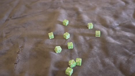 Point-of-view-angle-of-a-handful-of-lime-green-dice-being-rolled-in-slow-motion