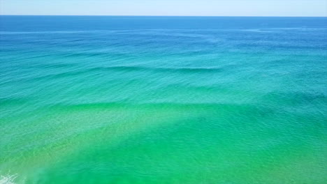 Aerial:-Drone-shot-flying-out-to-sea-over-a-turquoise-coloured-ocean