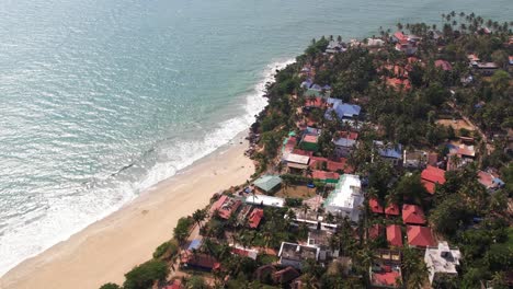 Aerial-View-Drone-Footage-Of-Varkala-Surrounded-By-Trees-And-Shoreline