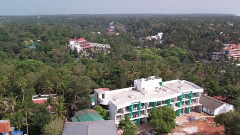 Aerial-shot-of-buildings-surrounded-by-forest-trees-in-the-cliff