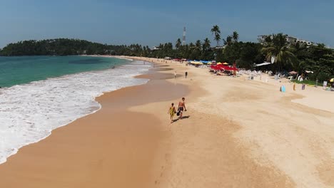 Kamerafahrt-Von-Menschen,-Die-Barfuß-Am-Langen-Sandstrand-Spazieren-Gehen-Und-Den-Sommer-Genießen,-Sri-Lanka