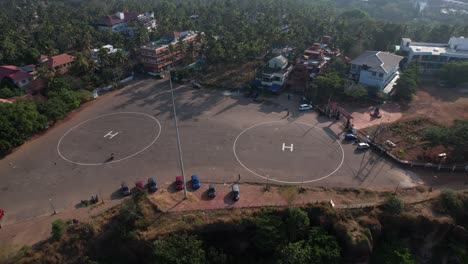 Aerial-drone-footage-of-Varkala-Helipad-surrounded-by-Buildings-and-Trees