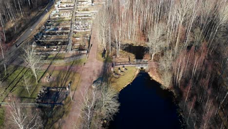 Establishing-shot-and-aerial-view-of-Gärdsåsmosse-natural-parkland-in-Bergsjön,-Gothenburg,-Sweden---Drone-shot-during-afternoon-late-winter-early-spring---people-walking-in-nature-park-in-Europe