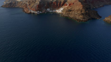 Panoramic-aerial-tilt-reveal-shot-of-Oia-in-Santorini,-Greece-during-sunset,-4K-prores