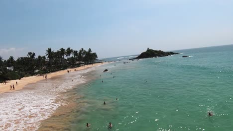 Luftaufnahme-In-Zeitlupe-über-Menschen,-Die-In-Warmem-Wasser-Schwimmen-Und-Die-Sommerzeit-Genießen,-Sri-Lanka