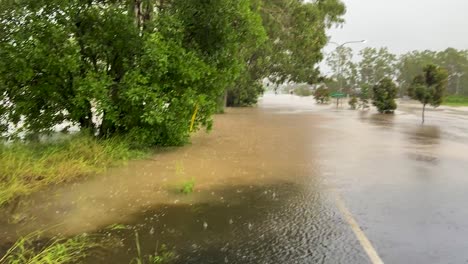 Queensland,-NSW,-Australia,-February-floods---flood-waters-run-in-torrents-along-the-roadside-and-inundate-a-major-road-junction-in-Australia's-February-2022-floods