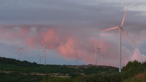 Wind-turbines-spinning-on-mountain-plateau-with-dramatic-clouds-in-background