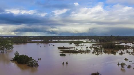 Queensland,-NSW,-Australia,-February-floods---dramatic-aerial-drone-shot-rising-over-inundated-flood-plains-in-Brisbane,-under-dramatic-stromy-skies