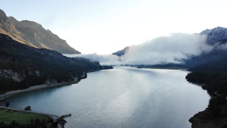 Ein-Sonnenaufgang-überflug-über-Dem-Silsersee-In-Maloja,-Schweiz-Mit-Blick-Auf-Die-Engadiner-Gipfel-Und-Wolken-über-Dem-Wasser