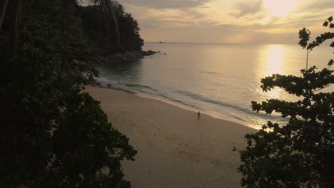 Woman-in-bikini-walking-on-tropical-beach-during-magical-sunset,-Thailand