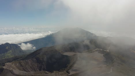 Irazu-Volcano-crater-with-Turrialba-volcano-in-background,-flying-through-cloud,-aerial