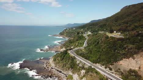 Aerial:-Drone-flying-lower-towards-a-highway-on-a-beautiful-coastline-in-New-South-Wales-Australia
