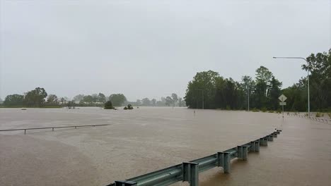 Queensland,-NSW,-Australia,-February-floods---devastating-and-dirty-flood-waters-inundate-a-Brisbane-road-system,-with-torrential-rain-falling-heavily