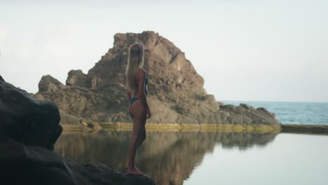 Hot-sexy-blond-bikini-model-in-coastal-rock-cave-with-natural-ocean-pool