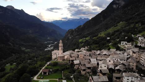 Aerial-flyover-over-the-historical-village-of-Soglio-in-the-Bregaglia-region-of-Grissons,-Switzerland-with-a-view-of-the-old-church-and-Bregaglia-valley