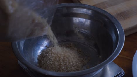 Pouring-Brown-Sugar-Into-Stainless-Bowl-For-Baking
