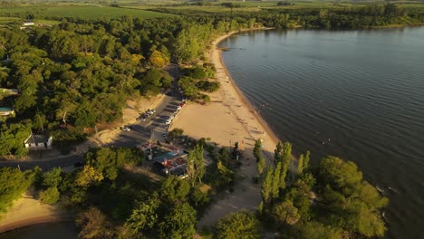Aerial-view-showing-beautiful-coastline-with-sandy-beach-at-river-in-Uruguay-during-sunset---Fray-Bentos,South-America