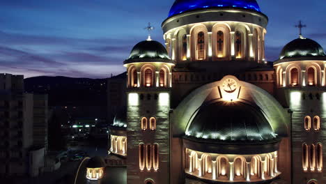 Medio,-Toma-Aérea-De-La-Catedral-Ortodoxa-Iluminada-En-El-Centro-De-Deva,-Rumania