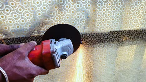 Close-up-of-laborer-holding-circular-cutter-blade,-cutting-iron-nails