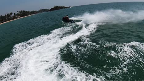 Aerial-Drone-Over-Man-Doing-Extreme-Water-Sports-Tricks-On-Jet-Ski-In-Blue-Ocean-Off-Sri-Lanka-Beach