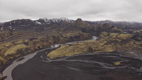 Panoramic-view-of-Icelandic-Highlands-surrounded-by-volcanic-black-desert-soil-with-rivers-running-through---Circling-Aerial-Dolly-Shot
