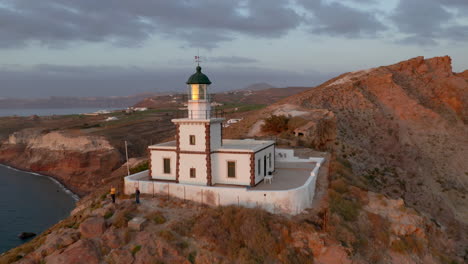 Antenne-Rückwärts-Aufschlussreiche-Aufnahme-Des-Leuchtturms-Akrotiri-In-Santorini,-Griechenland-Während-Der-Abenddämmerung
