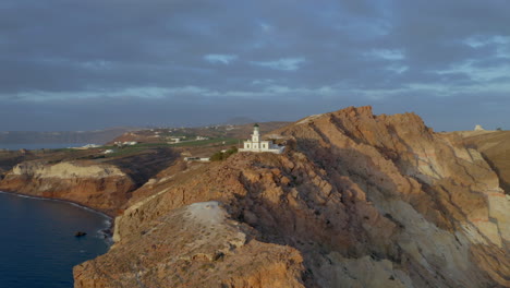 Luftpanoramablick-Auf-Den-Leuchtturm-Akrotiri-Auf-Santorini,-Griechenland-Während-Des-Sonnenuntergangs