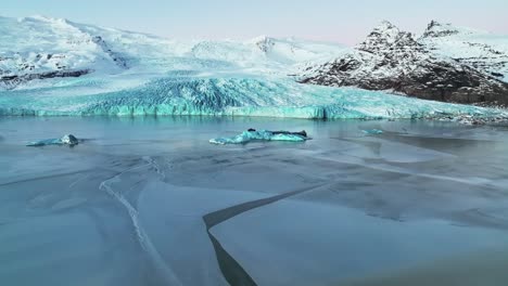 Floating-Icebergs-In-Fjallsarlon-Glacier-Lagoon-In-South-Iceland---aerial-drone-shot