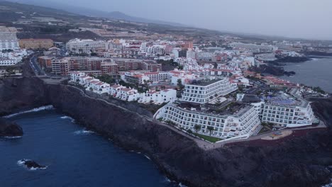 Costa-Adeje-Tenerife-Spain-Canary-Islands-Aerial-footage-hotels-resort-vacation-sunset-waves-black-rocks