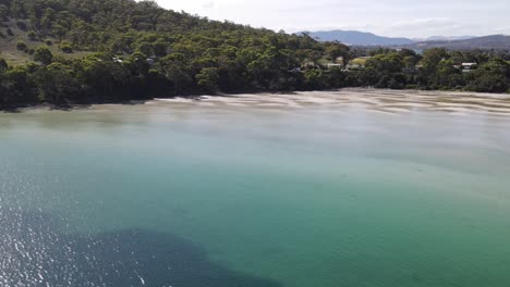 Drone-aerial-parallax-over-tropical-blue-water-in-Summer-Tasmania-with-nature-and-mountains