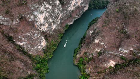 AERIAL---Boat-on-Grijalva-River,-Sumidero-Canyon,-Chiapas,-Mexico,-reverse-tracking-shot