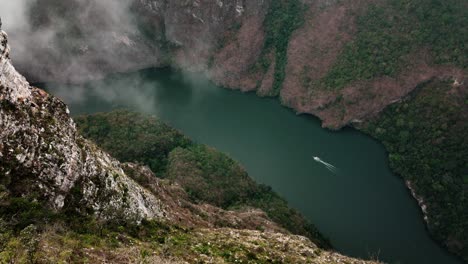 AERIAL---Boat-on-Grijalva-River-in-Sumidero-Canyon,-Chiapas,-Mexico,-spinning-shot