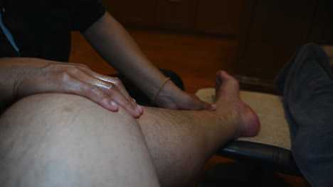 Left-hand-running-down-the-leg-with-pressure-during-a-Foot-massage-with-some-Thai-Massage-or-Nuat-Phaen-Thai,-Thailand