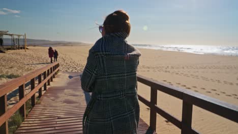 Handheld-shot-of-woman-walking-at-the-beach-path
