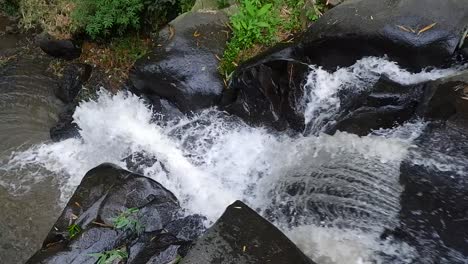Das-Rauschende-Flusswasser-Fließt-Durch-Die-Schwarzen-Felsen