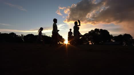 Silhouette-Von-Kindern-Auf-Einer-Lichtung-Im-Amazonas-Regenwald,-Die-Während-Eines-Atemberaubenden-Sonnenuntergangs-Fußball-Spielen