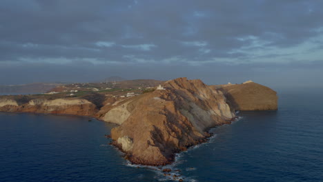 Toma-Panorámica-De-Drones-Del-Faro-De-Akrotiri-En-Santorini,-Grecia-Durante-La-Puesta-De-Sol