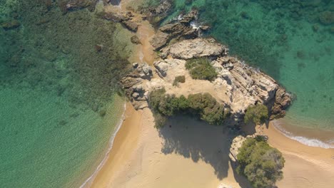 Top-down-view-over-a-beautiful-rocky-empty-beach-in-Spain-during-a-sunny-day