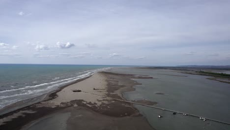 Drone-video-over-the-Divjake-Karavasta-nature-park,-Upward-frontal-shot-advancing-between-the-beach-and-the-nature-park,-leaving-the-sea-to-one-side
