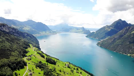 Aerial-flyover-over-the-vibrant-green-shores-of-Lake-Lucerne-on-a-sunny-summer-day-near-Seelisberg-in-Uri,-Switzerland